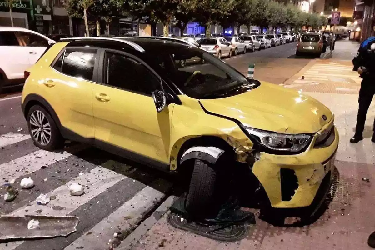 Coche amarillo accidentado con una calle de Lugo