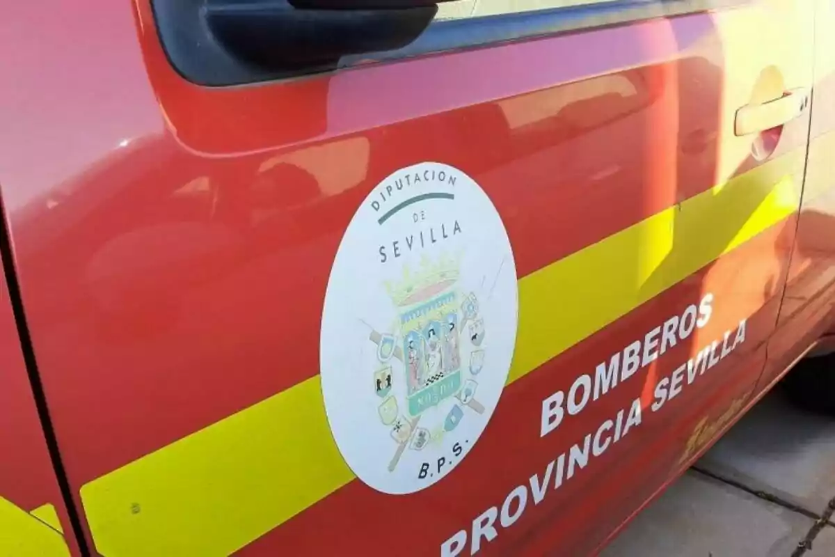 Camioneta roja de los bomberos de la provincia de Sevilla con el escudo de la Diputación de Sevilla en la puerta.