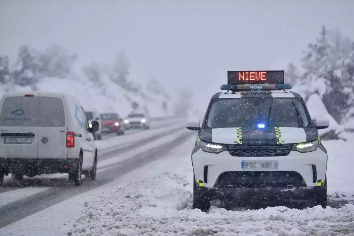 Un coche de la Guardia Civil sobre la nieve indicando que la carretera está cerrada