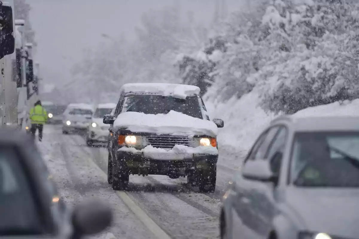 Vehículos circulan por una carretera nevada