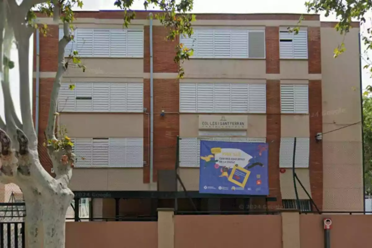 Edificio de ladrillo con ventanas blancas y un cartel azul en la fachada. Edificio de ladrillo con ventanas blancas y un cartel azul en la fachada.