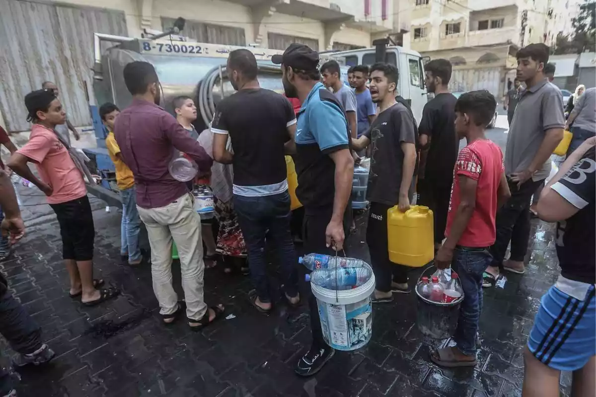 Unos palestinos con contenedores emiten un pitido desde un vehículo de distribución de agua, midiendo la crisis hídrica provocada por el asedio israelí a la Franja de Gaza, a las 6.00 horas del día de los continuos combates entre Israel y Hamás. Unos palestinos con contenedores emiten un pitido desde un vehículo de distribución de agua, midiendo la crisis hídrica provocada por el asedio israelí a la Franja de Gaza, a las 6.00 horas del día de los continuos combates entre Israel y Hamás.