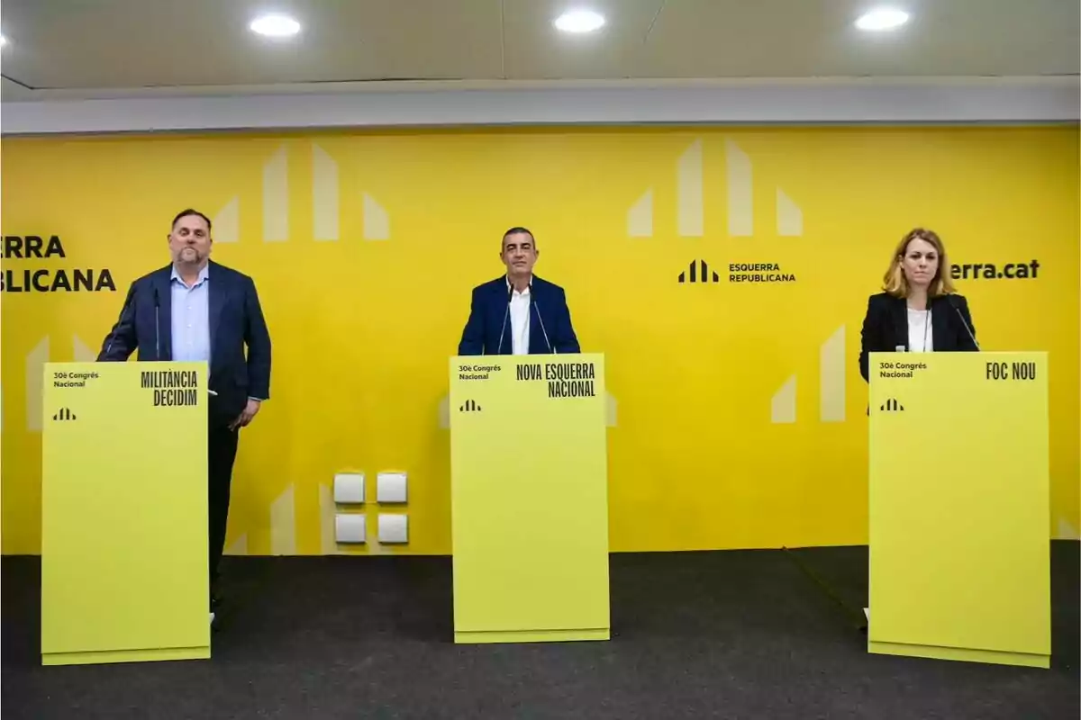 Tres personas de pie detrás de atriles amarillos en un evento de Esquerra Republicana con un fondo amarillo.