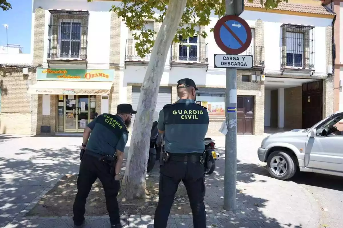 Guardia Civil de espaldas delante de uana casa