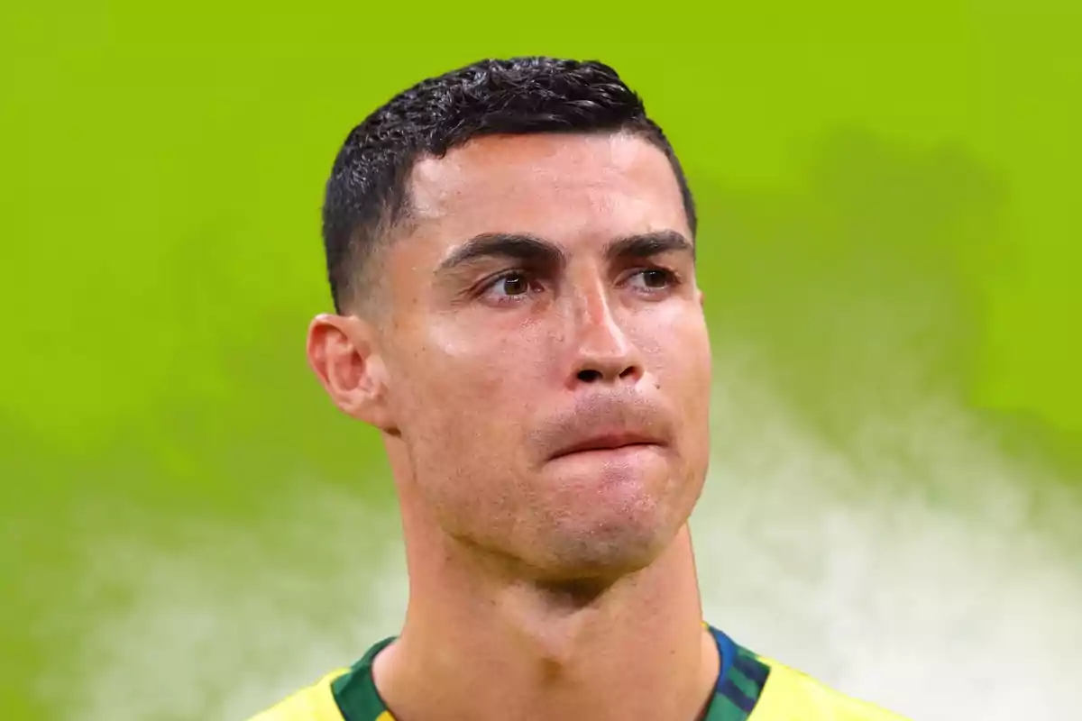 Hombre de cabello corto y oscuro con expresión seria sobre un fondo verde difuminado