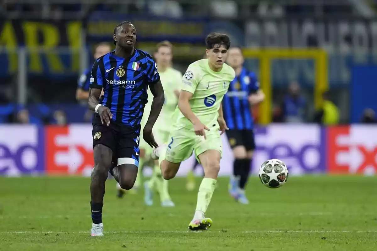 Jugadores de fútbol corren tras el balón en un partido, uno lleva uniforme azul y negro y el otro verde claro. Jugadores de fútbol corren tras el balón en un partido, uno lleva uniforme azul y negro y el otro verde claro.