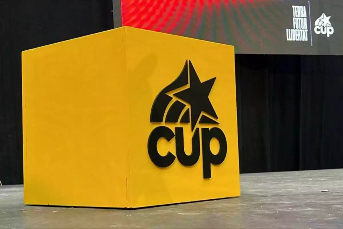 Cubo amarillo con el logotipo negro de la CUP y una estrella en un escenario