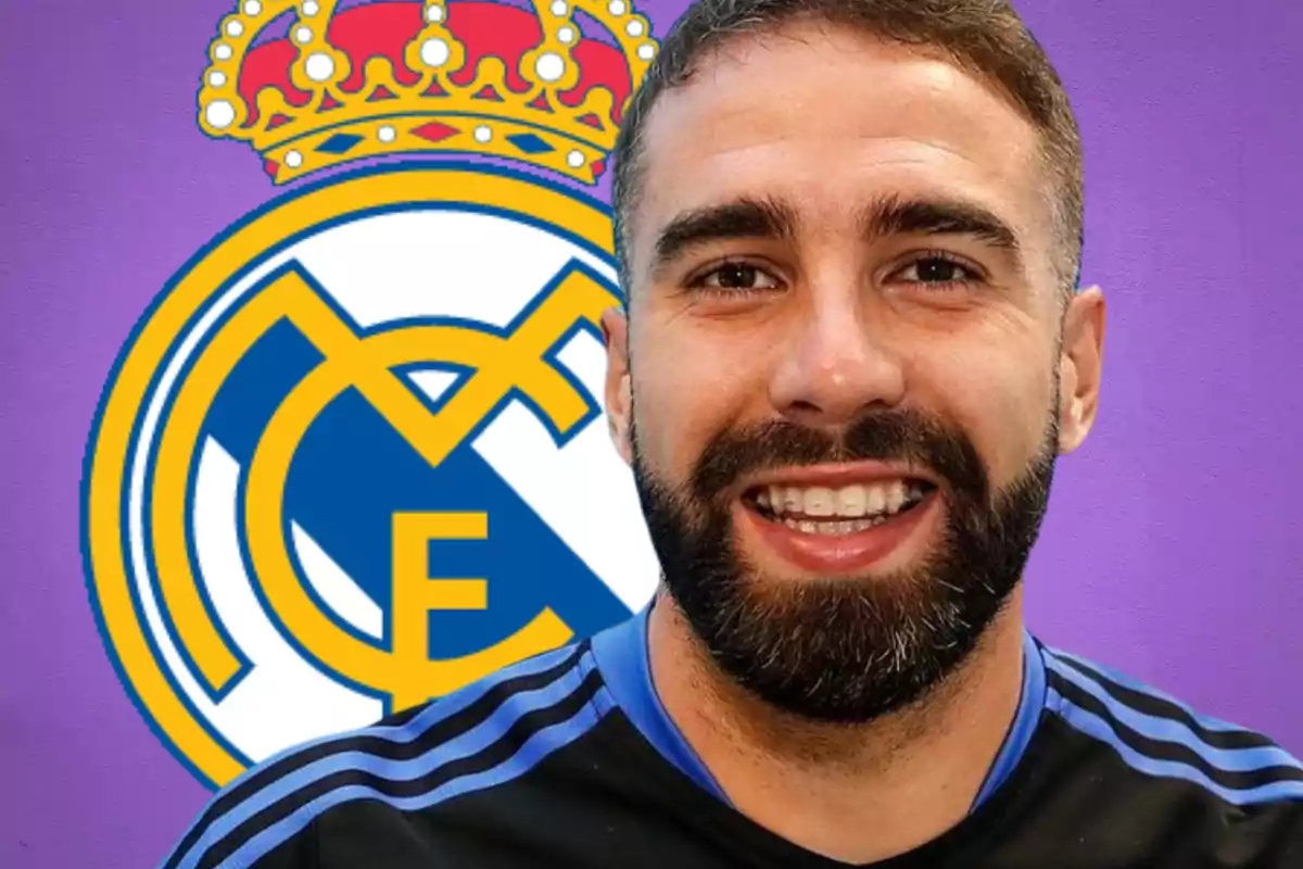 Un hombre sonriente con barba frente al escudo del Real Madrid sobre un fondo morado.