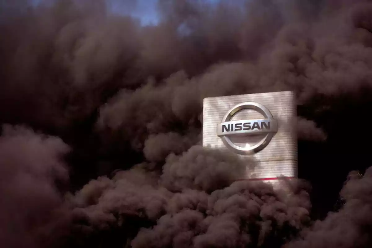 un cielo azul tapado por humo marrón muy espeso y enmedio un edificio blanco con el logo de Nissan