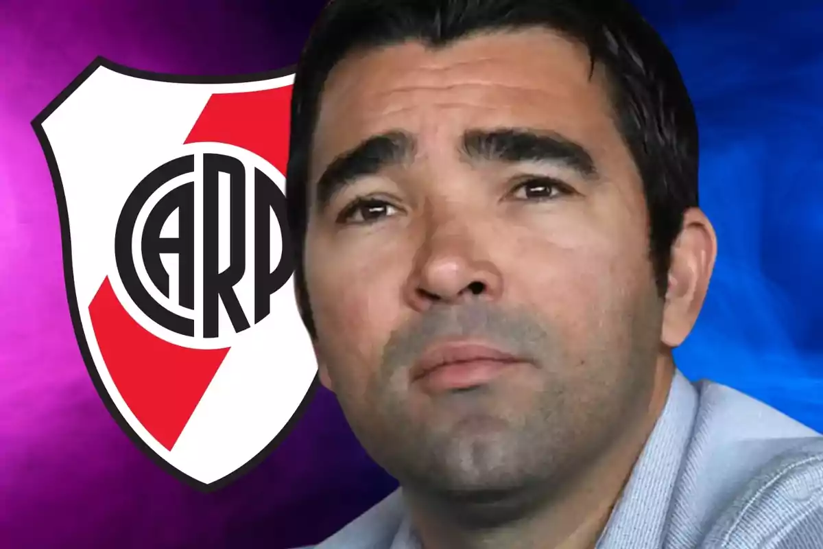 Un hombre con expresión seria frente a un fondo con el escudo de River Plate.