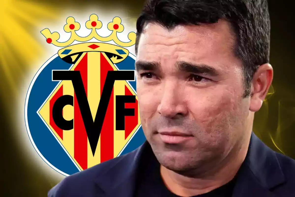 Un hombre con expresión seria frente al escudo del Villarreal CF.