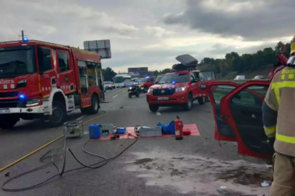 Un accidente en la carretera con vehículos de bomberos y equipos de emergencia presentes.