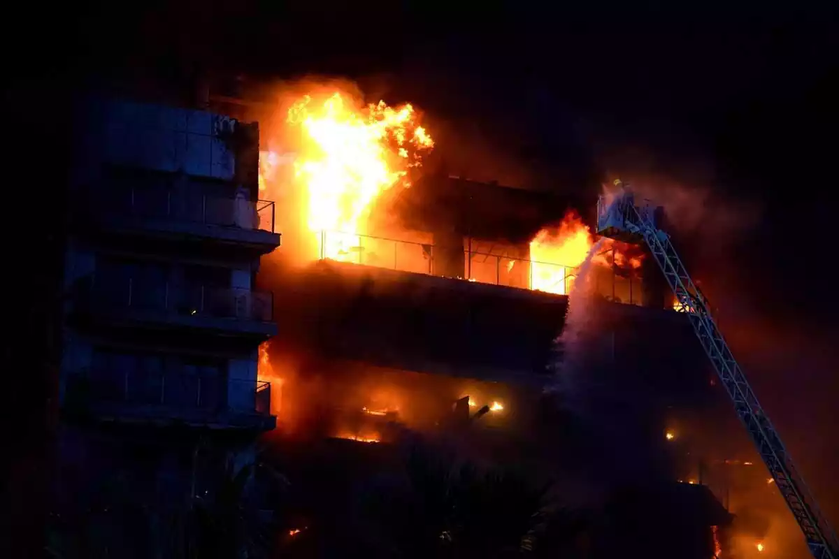 Los bomberos tratan de apagar las llamas de un edificio, en el barrio de Campanar, a 22 de febrero de 2024, en Valencia