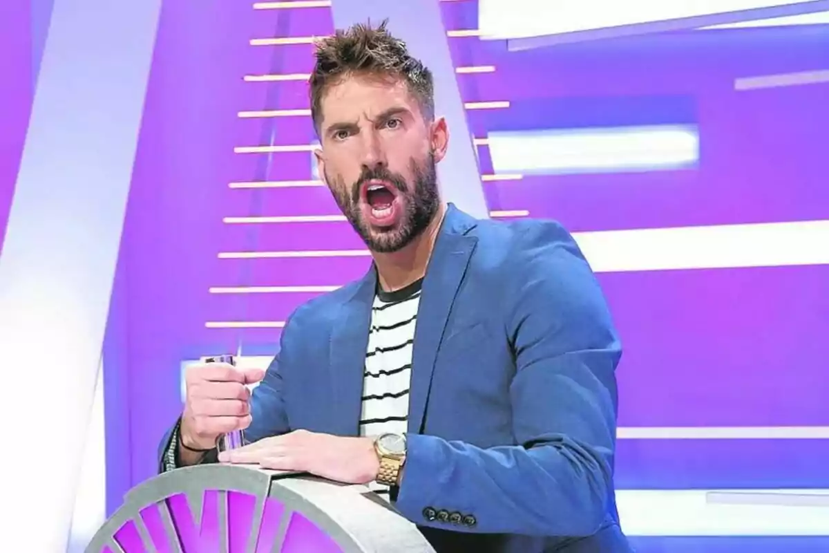 Egoitz Txurruka con barba y chaqueta azul mostrando una expresión de sorpresa en un set de televisión con fondo morado Egoitz Txurruka con barba y chaqueta azul mostrando una expresión de sorpresa en un set de televisión con fondo morado