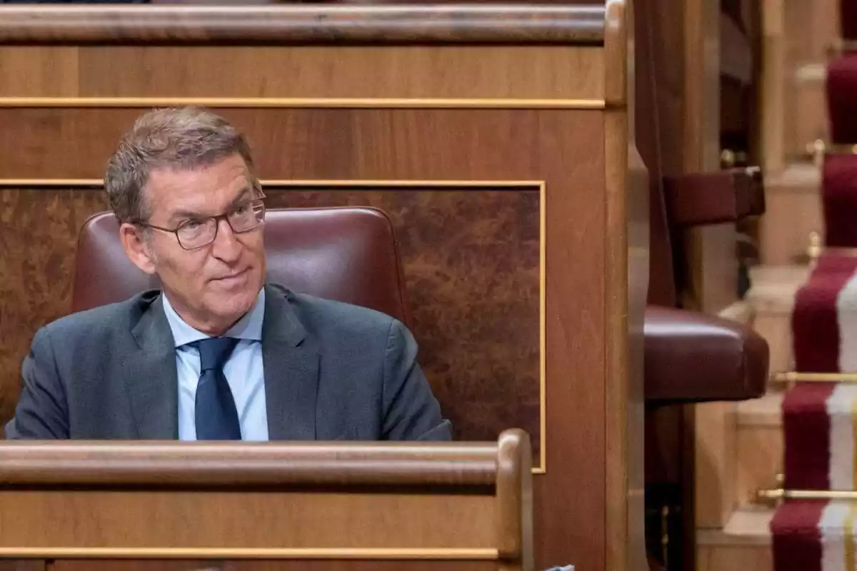 El presidente del PP, Alberto Núñez Feijóo sentado en el congreso con expresión seria