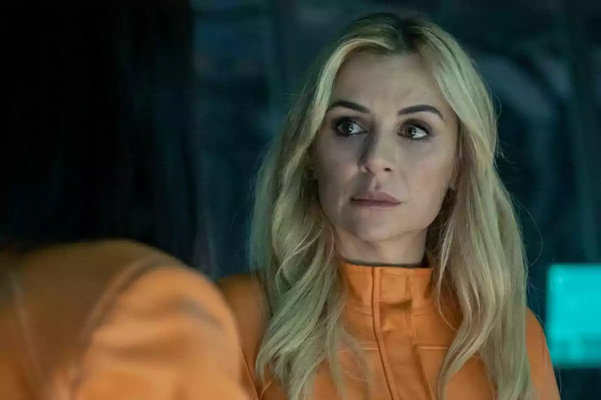 Miren Ibarguren rubia con expresión seria usando un uniforme naranja en un entorno oscuro en El Refugio Atómico