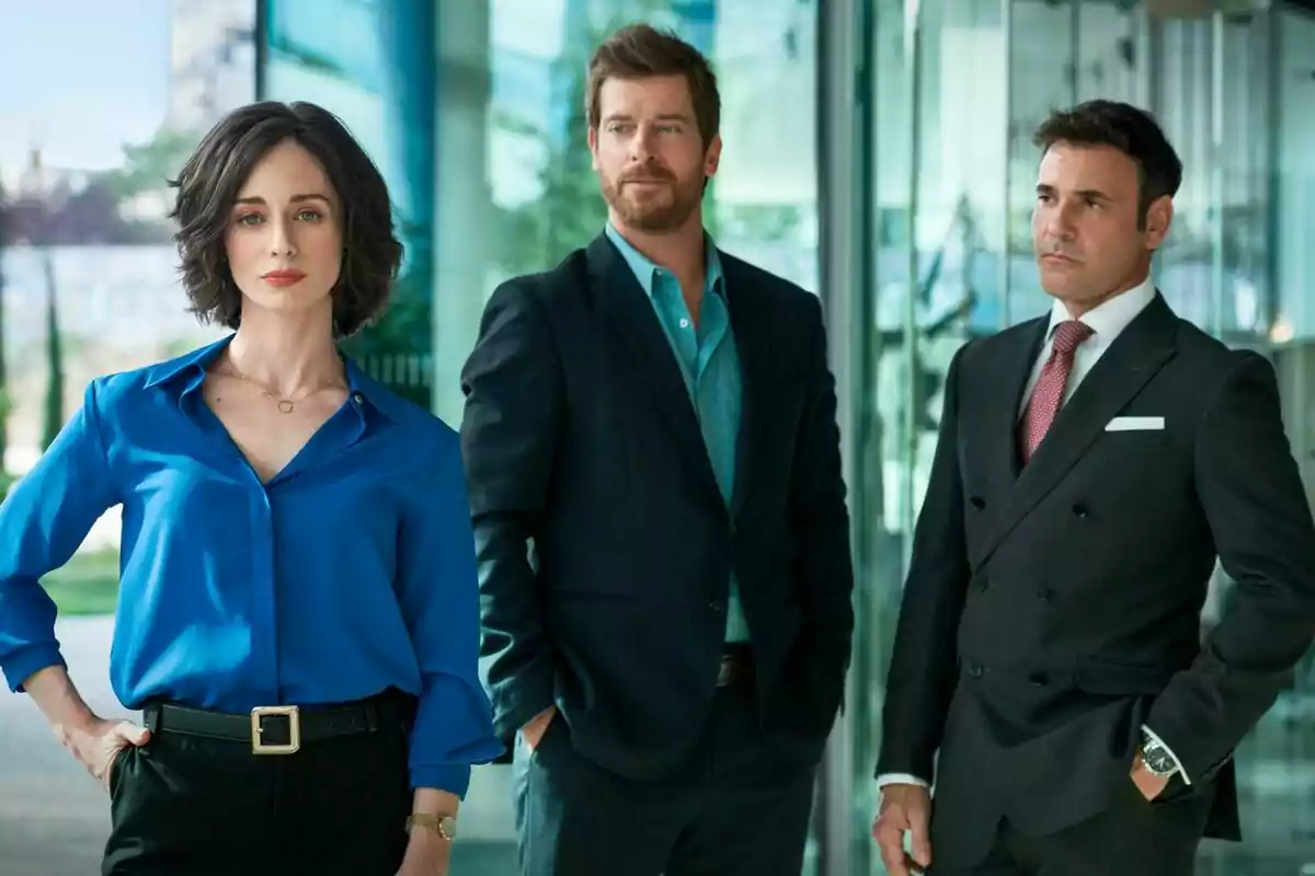 Elena Rivera, Manu Baqueiro y Miquel Fernández vestidas de manera formal posan en un entorno moderno y elegante en la serie Perdiendo el Juicio.