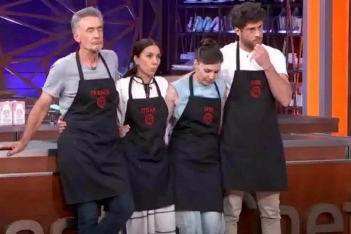 Francis Lorenzo, Itziar Miranda, Inés Hernand y José Lamuño con delantales negros y nombres bordados en rojo están de pie en un set de cocina en MasterChef Celebrity.