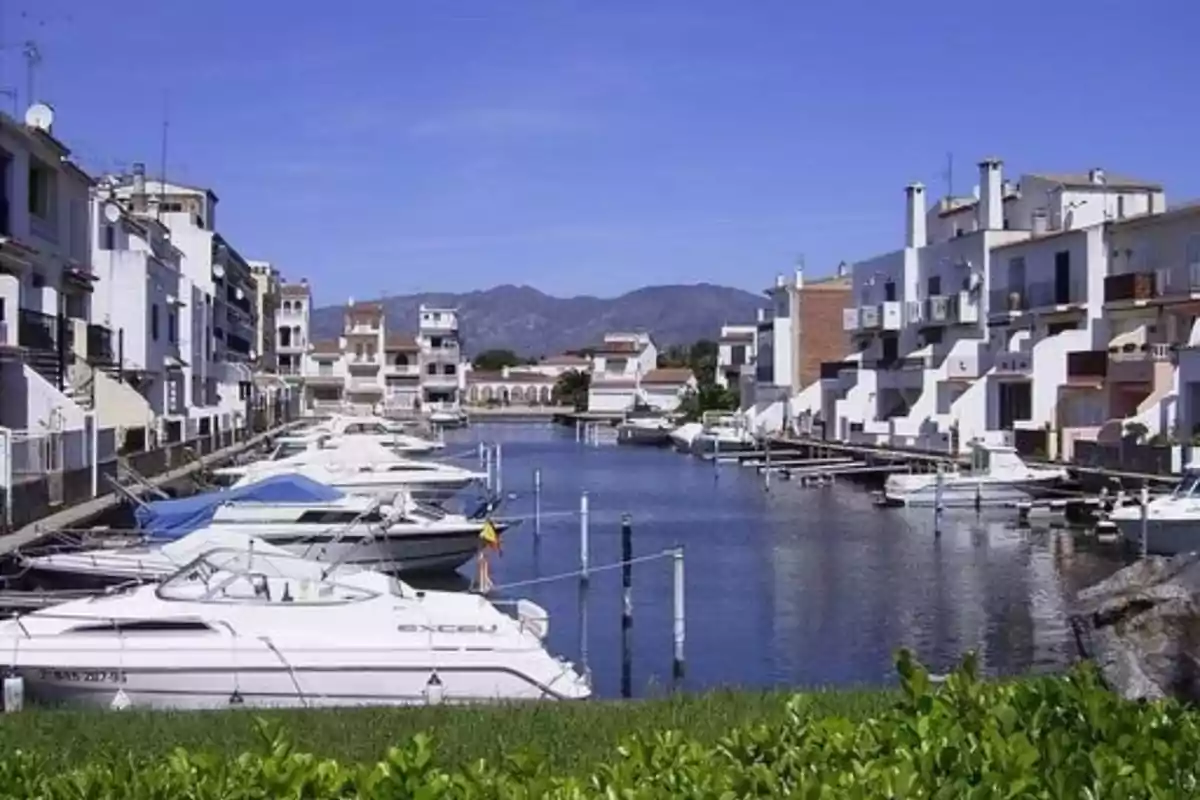 Vista de un canal con barcos y casas a ambos lados en un día soleado. Vista de un canal con barcos y casas a ambos lados en un día soleado.