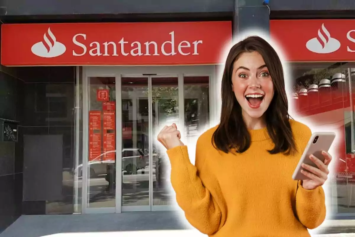 Una mujer sonriente con un teléfono móvil frente a una sucursal del banco Santander.