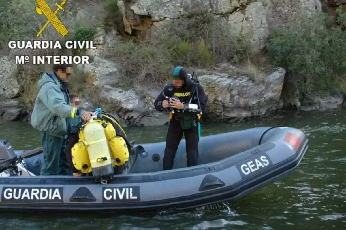 Imagen de un equipo de salvamento de la Guardia Civil con los neoprenos encima de una lancha