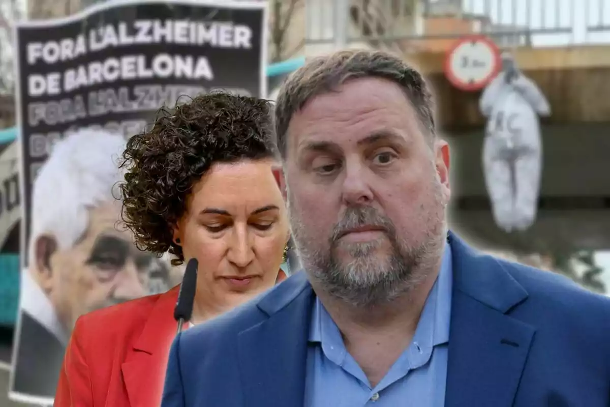 Dos personas en primer plano con un cartel de fondo que dice "Fora l'Alzheimer de Barcelona" y una figura colgada en la parte trasera.