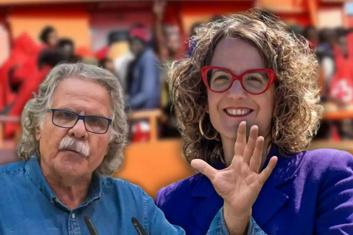 Dos personas con gafas posan frente a un fondo desenfocado de colores cálidos.