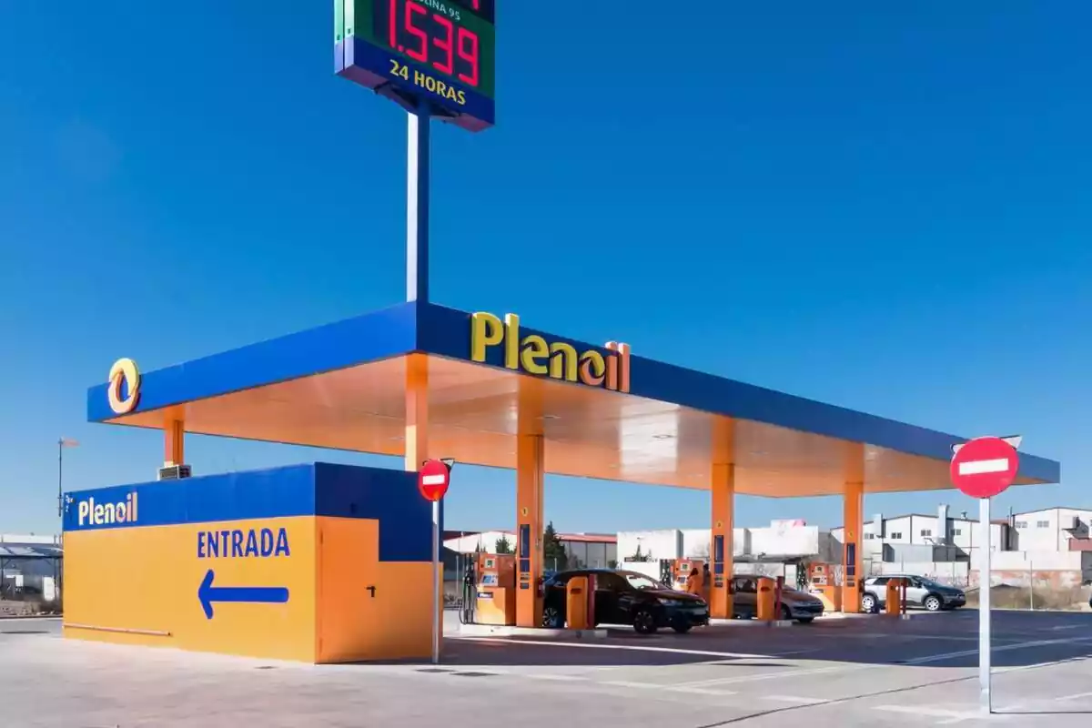 Estación de servicio de la empresa Plenoil con varios coches repostando Estación de servicio de la empresa Plenoil con varios coches repostando