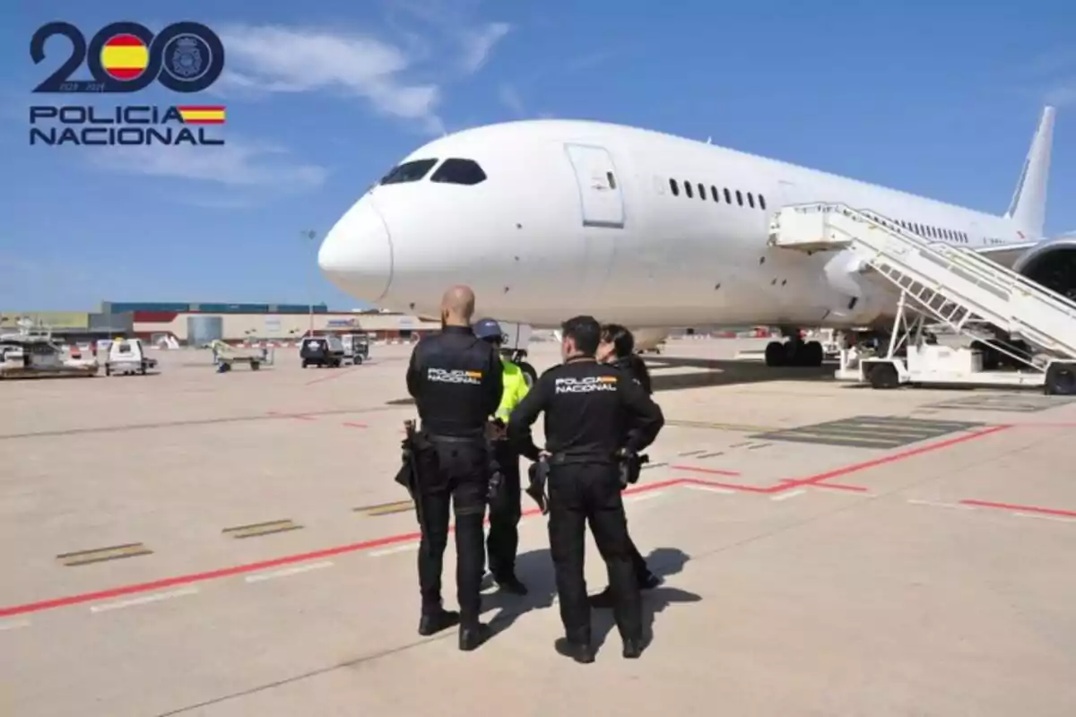 Policías nacionales de España en un aeropuerto junto a un avión blanco.