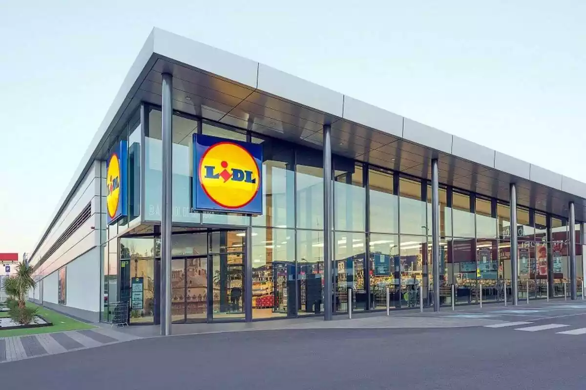 Vista exterior de una nueva tienda de Lidl en España con 2 logos a la vista y luz en el interior
