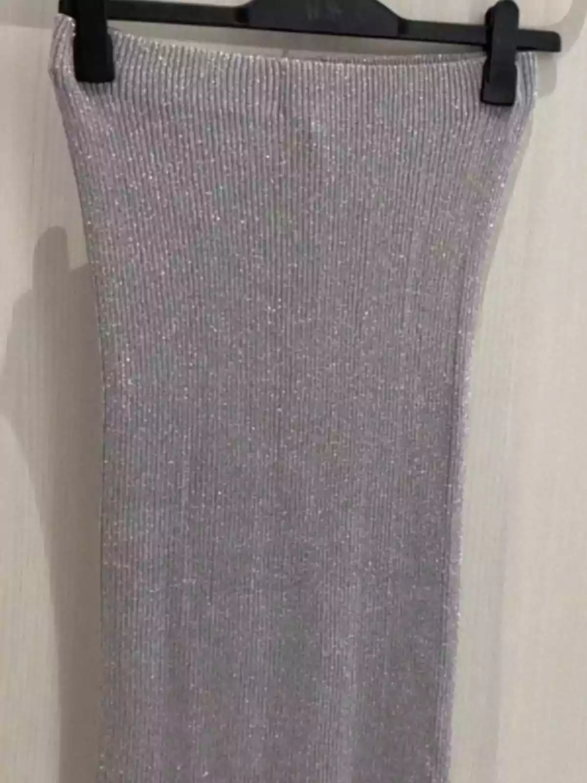 Imagen de una falda en color plata de H&M colgada de una percha Imagen de una falda en color plata de H&M colgada de una percha