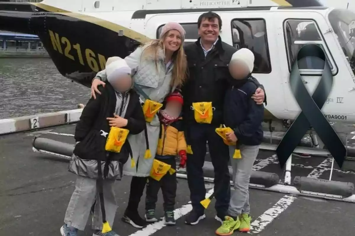 Una familia sonriente posa frente a un helicóptero en un helipuerto, todos llevan chalecos salvavidas amarillos y hay un lazo negro superpuesto en la imagen.