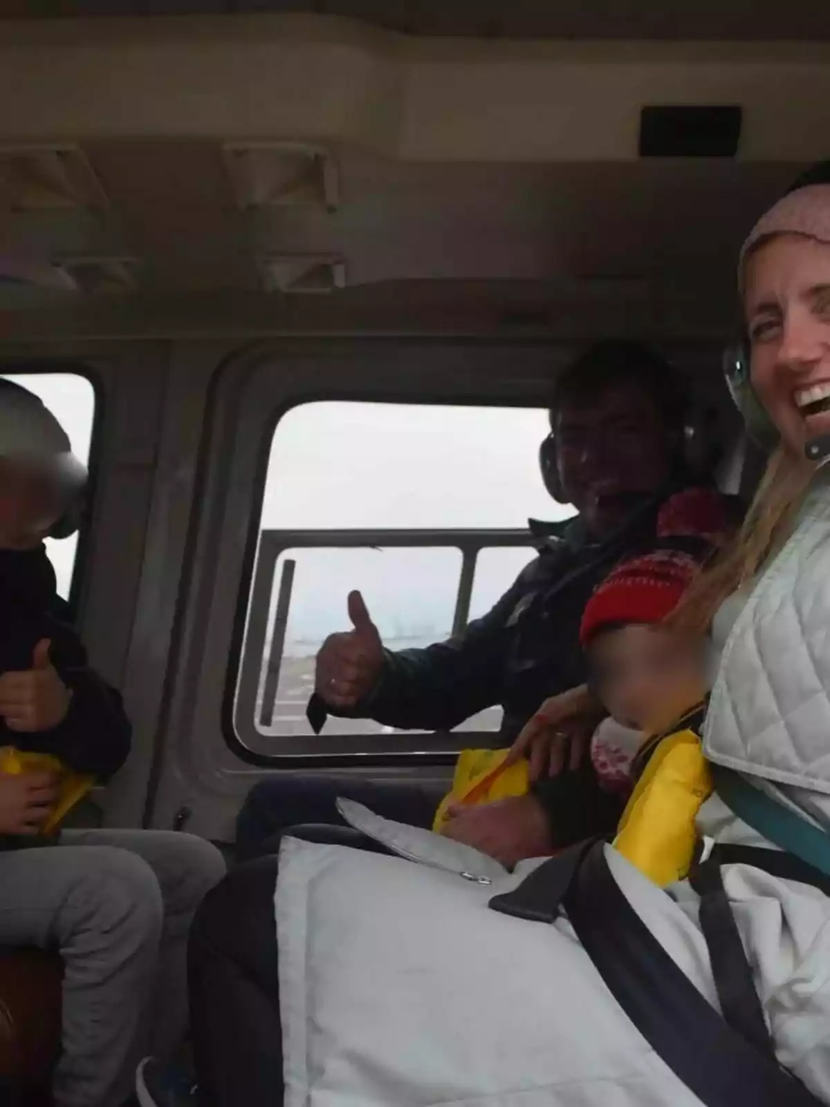 Personas sonriendo y haciendo el gesto de pulgar arriba dentro de un helicóptero. Personas sonriendo y haciendo el gesto de pulgar arriba dentro de un helicóptero.