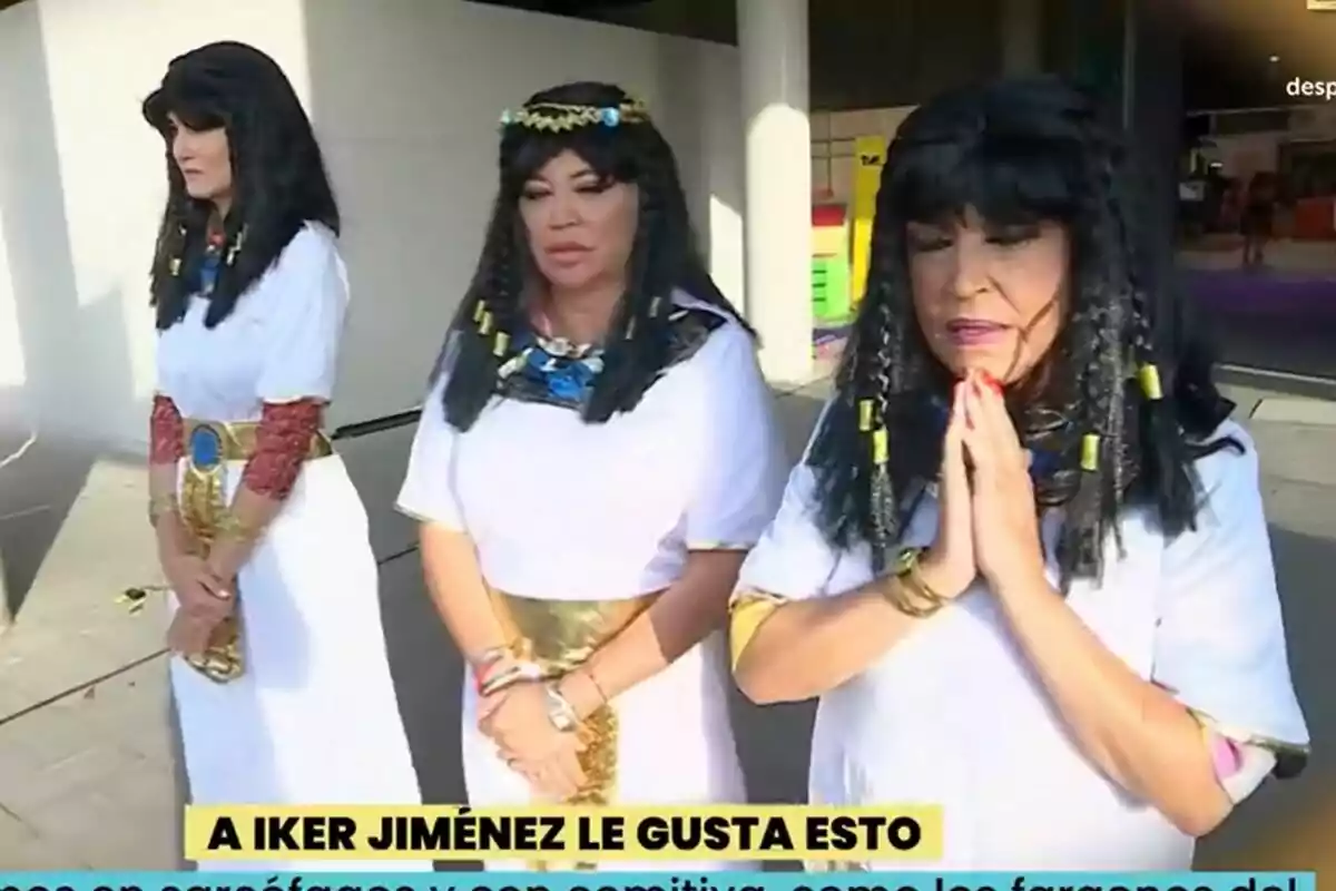 Alba Carrillo, Belén Esteban y Lydia Lozano vestidas con disfraces de estilo egipcio posan al aire libre en La Familia de la Tele, una de ellas con las manos juntas en actitud de oración y un rótulo amarillo en la parte inferior que dice A IKER JIMÉNEZ LE GUSTA ESTO