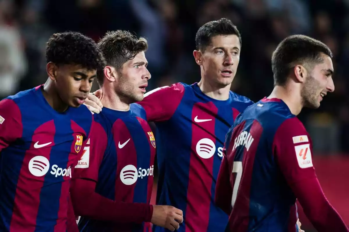 Varios futbolistas del FC Barcelona se abrazan tras marcar un gol