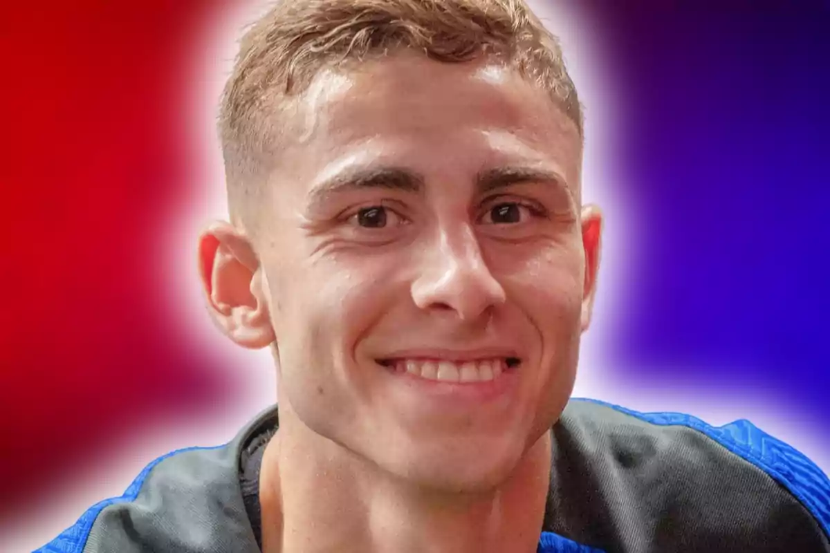 Un hombre joven sonriendo con un fondo degradado de colores rojo y azul.
