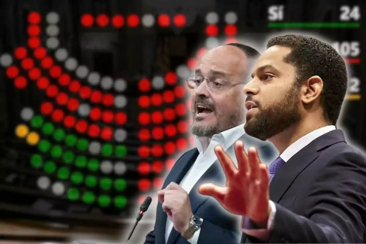 Dos hombres debaten en un parlamento con un tablero de votación de fondo mostrando luces rojas, verdes, amarillas y blancas junto a los resultados de una votación