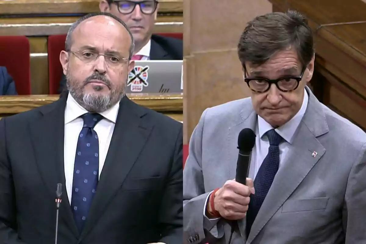 Dos hombres con traje y corbata participan en un debate en un entorno parlamentario uno de ellos sostiene un micrófono