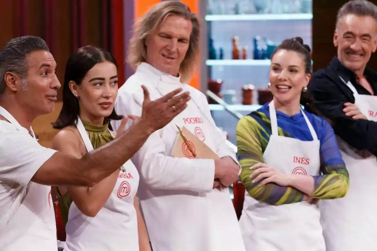 Pitingo, Marina Rivers, Inés Hernand, Pocholo y Francis Lorenzo con delantales blancos participa en MasterChef Celebrity, mostrando diversas expresiones faciales.