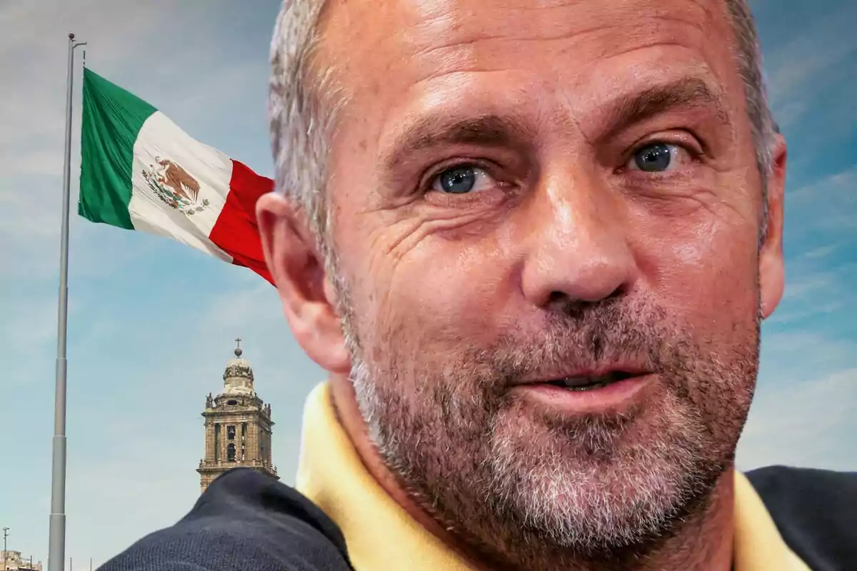 Un hombre de barba con una bandera de México y una torre de iglesia en el fondo.