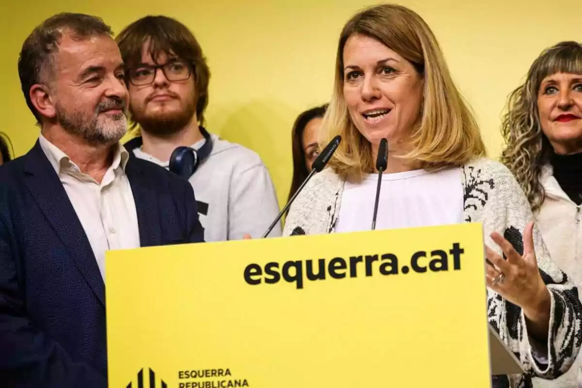 Un grupo de personas en un evento de Esquerra Republicana frente a un fondo amarillo.