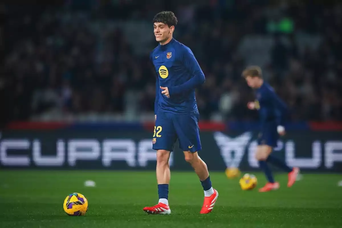 Un jugador de fútbol con uniforme azul y número 32 en el campo durante un partido. Un jugador de fútbol con uniforme azul y número 32 en el campo durante un partido.