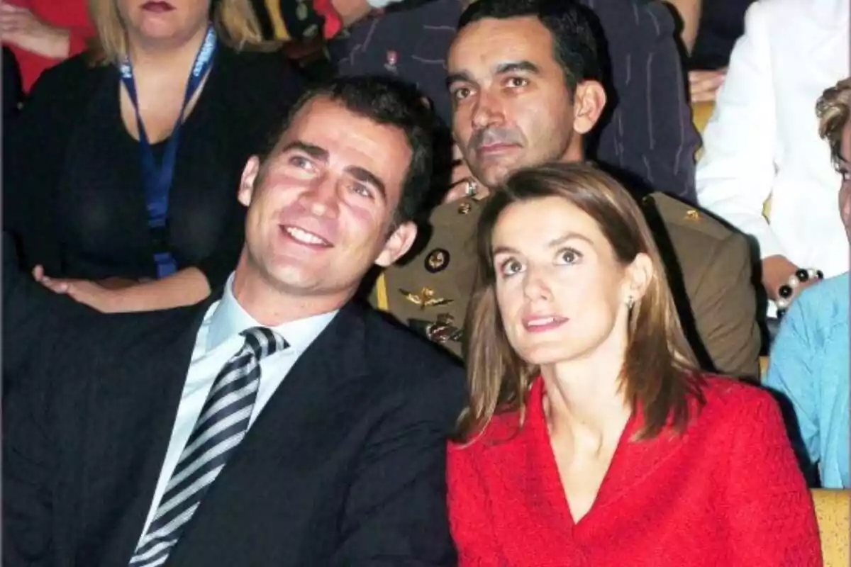 Foto de Felipe VI y Letizia de jovenes sentados el uno al lado del otro en una gala, sonrientes y vestidos para la ocasión con un traje y un vestido