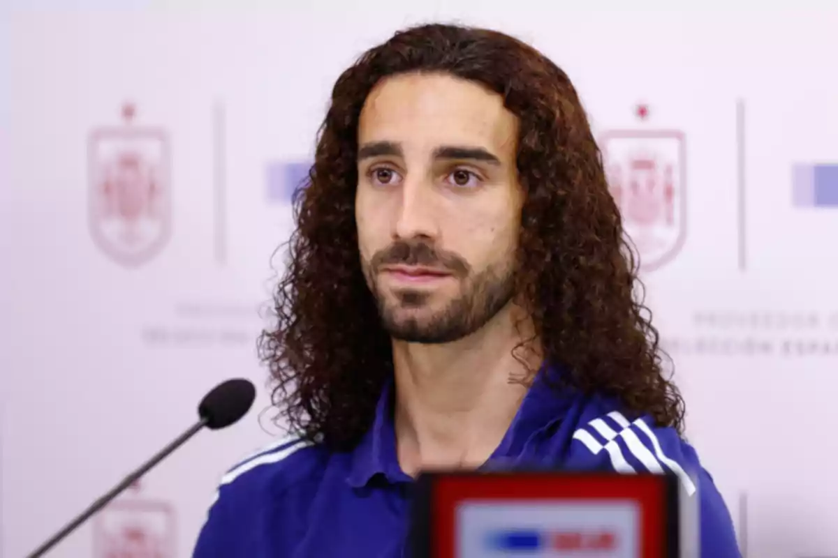 Marc Cucurella con cabello rizado y rojo y barba en una conferencia de prensa. Marc Cucurella con cabello rizado y rojo y barba en una conferencia de prensa.