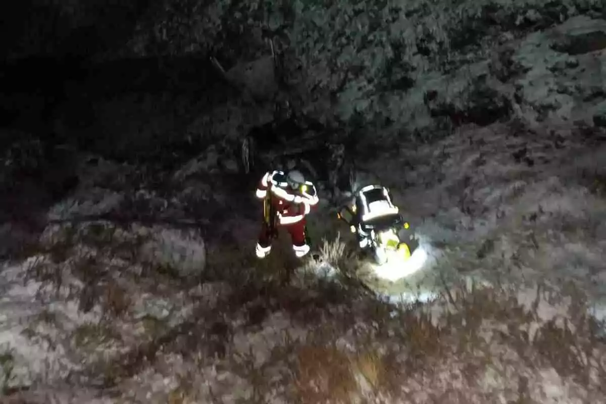 Un rescatista con equipo de iluminación trabaja en un terreno nevado y oscuro. Un rescatista con equipo de iluminación trabaja en un terreno nevado y oscuro.