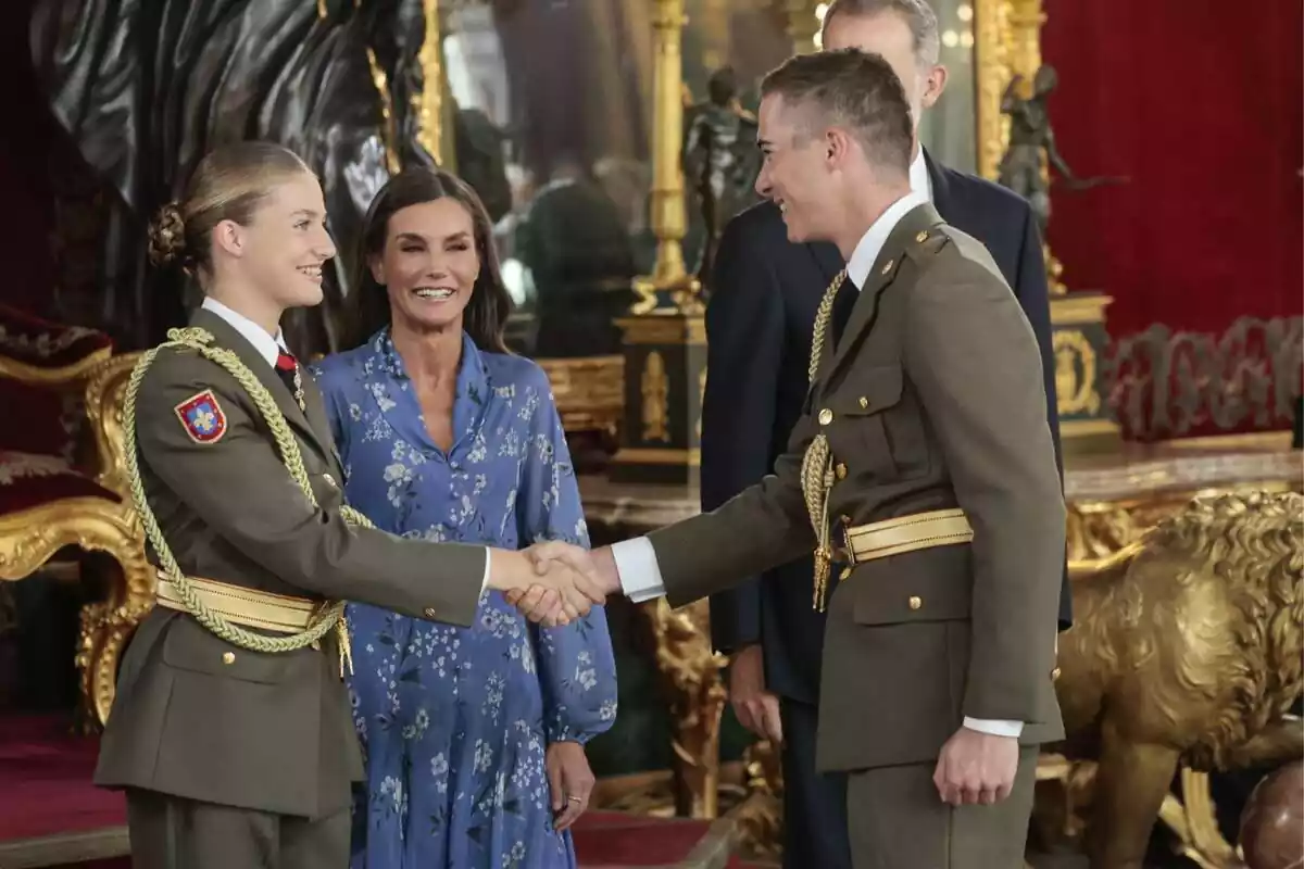 Foto de la princesa Leonor dándole la mano a uno de sus compañeros durante la recepción del Palacio Real, con la reina Letizia a su lado