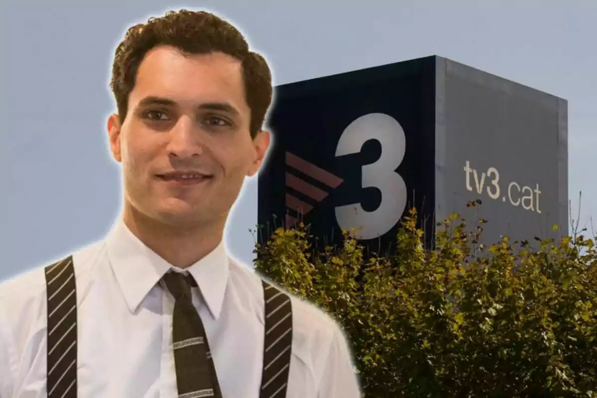 Un hombre con camisa blanca y tirantes oscuros está frente a un edificio con el logo de TV3 y el sitio web tv3.cat.