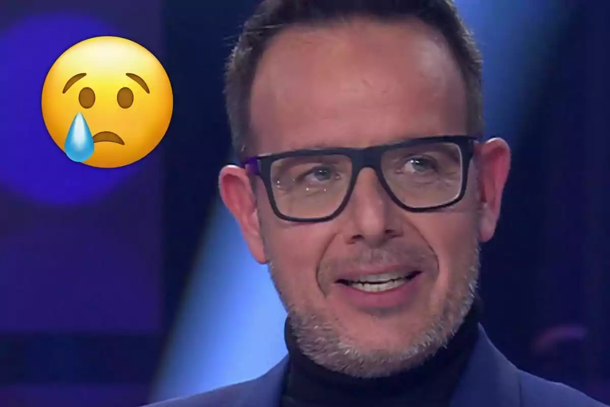 Àngel Llàcer con gafas y barba corta parece emocionado, acompañado de un emoji triste con una lágrima.