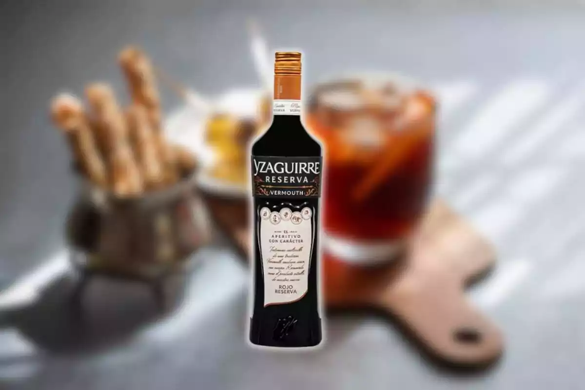 Fotomontaje con una imagen de fondo difuminada de una cata de vermut y al frente la botella del Vermouth Yzaguirre Rojo Reserva Fotomontaje con una imagen de fondo difuminada de una cata de vermut y al frente la botella del Vermouth Yzaguirre Rojo Reserva