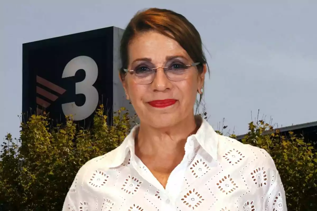 Una mujer con gafas y camisa blanca está frente a un edificio con un gran número 3 en el fondo.